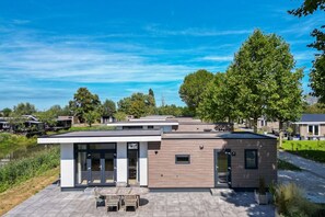 Un área residencial moderna con casas, un sendero pavimentado y una masa de agua.