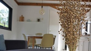 Un salon moderne avec un canapé, un coin repas et une cuisine en arrière-plan.