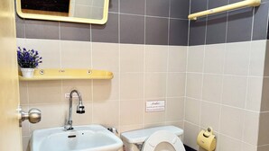Kylpyhuone, jossa on pesuallas, wc ja peili.