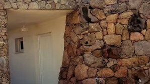 A stone wall with a doorway leading to a room. - Dependance Cugnana, surrounded by greenery and away from the chaos (Olbia)
