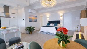 Une chambre d’hôtel moderne, équipée d’un lit, d’un bureau, d’une chaise, d’une table ornée d’un vase de fleurs et d’un tableau accroché au mur.