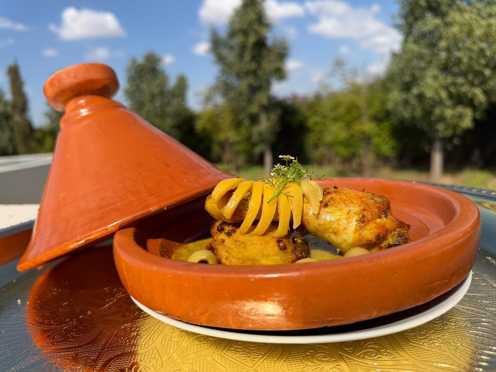 A traditional Moroccan tagine dish with a lid on a table.