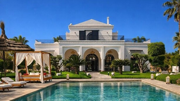 Ein Schwimmbecken mit klarem Wasser, ein Gebäude mit Rundbogenfenstern und ein Gazebo mit weißen Vorhängen.