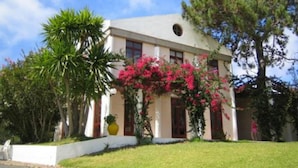 A building with a flat roof, large windows, and a well-maintained lawn.