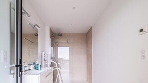 Ein modernes Badezimmer mit Duschkabine aus Glas, einem weißen Waschbecken und einem Spiegel.