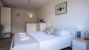 A modern hotel room with a bed, bedside table, and a wall-mounted artwork. -  1 bedroom apt in Korčula -Cozy Island Retreat /Walk Everywhere+Private Parking/ (Korčula)