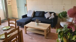 Ein Wohnzimmer mit einer Couch, einem Couchtisch und einem Essbereich mit Stühlen und einem Tisch.