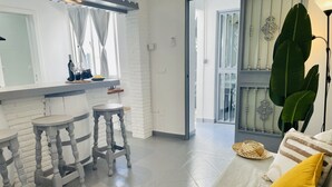 A modern kitchen with white brick walls, a bar area, and two stools. - Apartamento Caribe Panama by At Home Costa del Sol (Nerja)