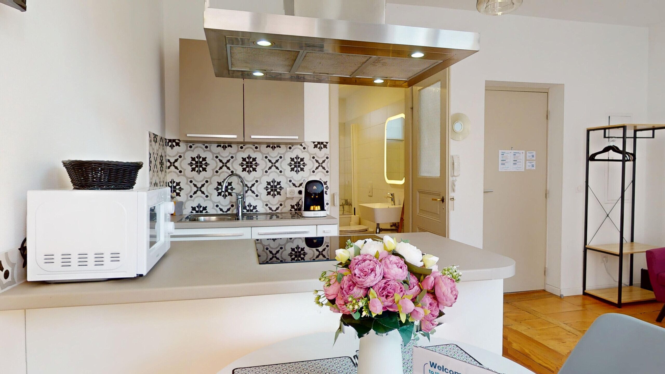 A modern kitchen with a microwave, a coffee machine, and patterned backsplash.