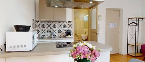 A modern kitchen with a microwave, a coffee machine, and patterned backsplash.