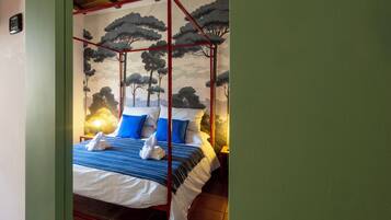 A bed with a canopy, a wall mural of trees, and a visible door.