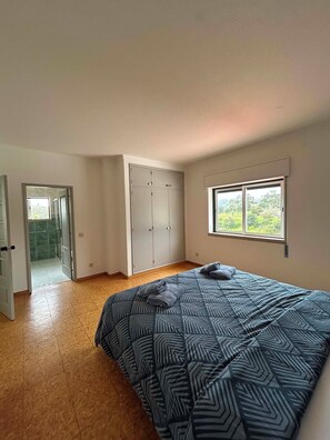 A bedroom with a bed, a wardrobe, a window with a view, and a door leading to a bathroom. - 5-Bedroom House with Private Pool in the Algarve, Silves (Silves)