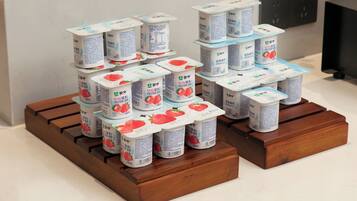 Envase de yogur apilado sobre bloques de madera.