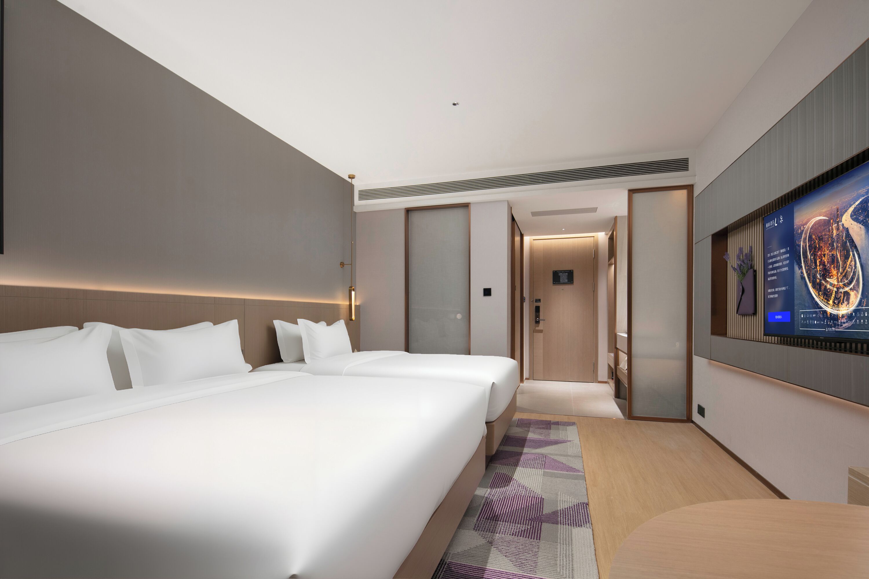 A hotel room with a large bed, a TV, and a view of the city.