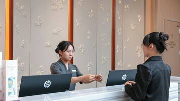 A reception desk with HP computers, a name tag, and a 'Danger Electric shock' sign.
