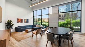 Un espace de bureau moderne doté d’une grande table de réunion, de sièges confortables et de larges fenêtres offrant une vue sur la ville.