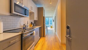 Une cuisine moderne dotée d’appareils électroménagers en acier inoxydable, d’un four à micro-ondes et d’un plancher en bois.