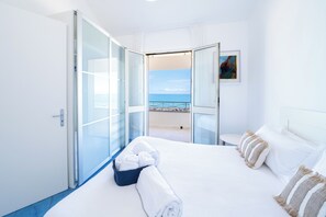 A hotel room with a bed, a view of the sea, and a balcony. - Amira Beach Villa by LeDhome (Trappeto)