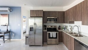 Una cocina moderna con electrodomésticos de acero inoxidable, armarios de madera y una isla grande con un lavamanos.