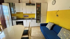 A compact kitchen with white cabinets, a microwave, and a gas stove. - Apartment Sleeps 3 - Private Garden - Pets Welcome (Realmonte)