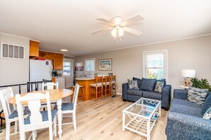 A compact living space with a dining area, kitchenette, and seating area. - Wynn's Way- 4BR, Dog Friendly, Ocean Views (Surf City)