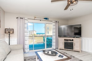 A living room with a balcony, a television, and a fireplace. - Beach Life - Updated Condo Near the Beach to Enjoy Beach Life (Surf City)