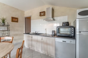 A compact kitchen with a dishwasher, a toaster oven, and a refrigerator. - Gite les vignes – La Bastide St Jacques: Provençal Retreat Amidst Organic Vineyards (Vinsobres)