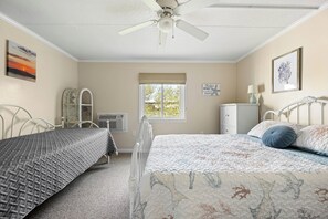 A bedroom with two beds, a ceiling fan, a window with a view, and a dresser. - Charming 1 Bedroom, Two Bath Condo in Desirable North Ocean City (Ocean City)