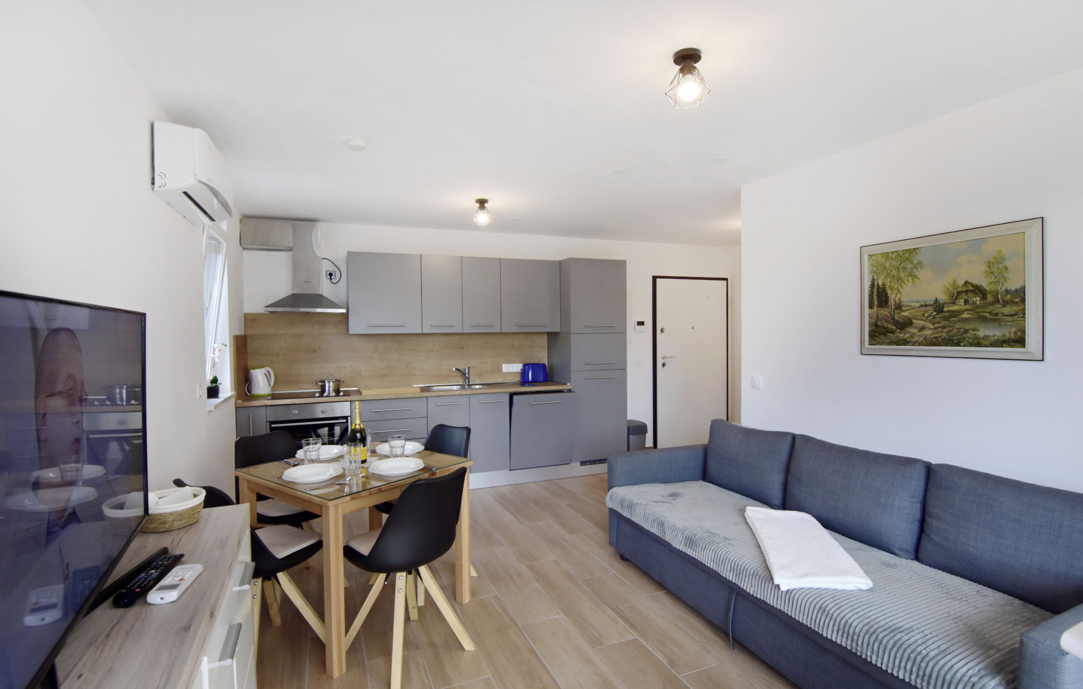 Un espacio habitable compacto con kitchenette, comedor y sofá.