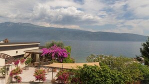 A hotel with a view of the sea, outdoor seating, and a covered patio area.