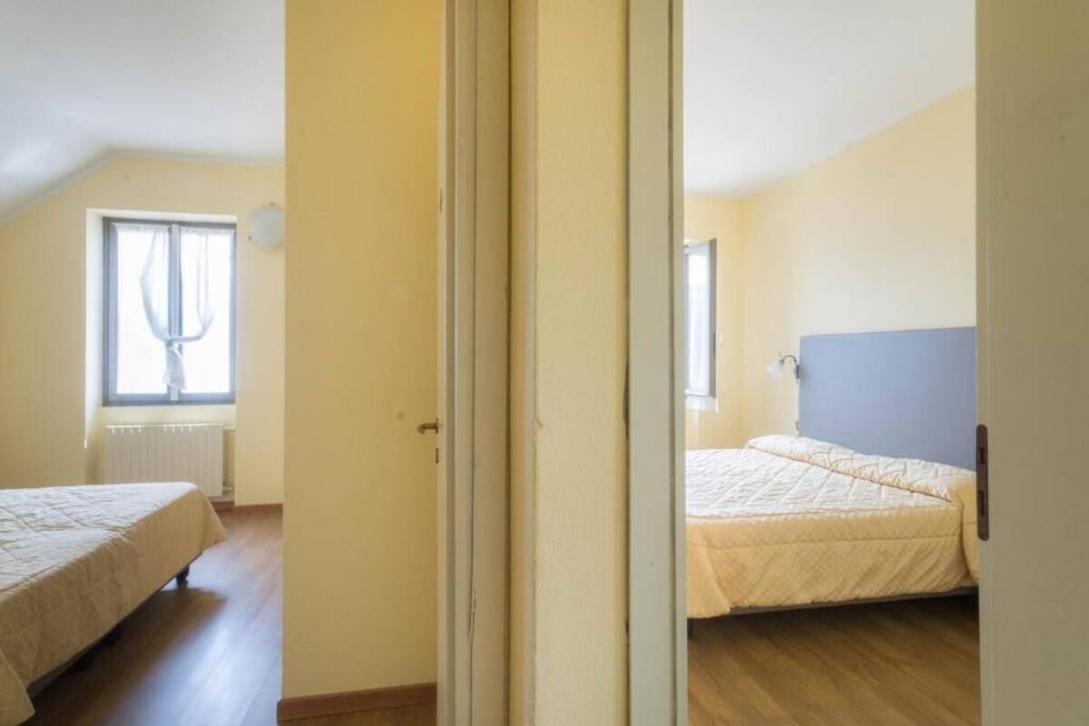 Een slaapkamer met een bed, een raam en een radiator.