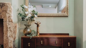 A wooden dresser with three drawers, a vase with white flowers, and a giraffe figurine. - Spacious 2 Bed House Lancaster (Lancashire)