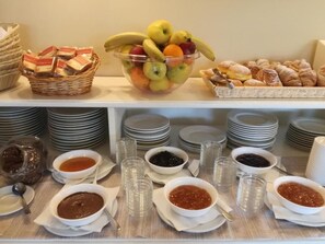 Ein reichhaltiges Buffet mit Obst, Gebäck und verschiedenen Soßen.