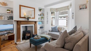 Una sala de estar acogedora con chimenea, televisor y un espacio de descanso cómodo.