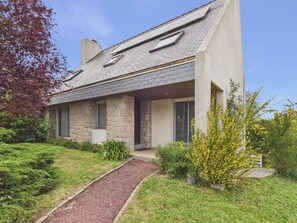 A modern house with a stone facade, a sloped roof, and a front porch. - Comfortable house for 9, with a garden and trees (Pléneuf-Val-André)