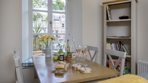 Een eettafel met uitzicht, een boekenkast en diverse etenswaren.