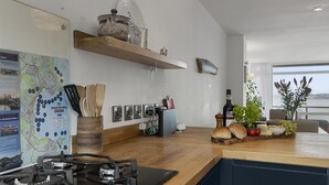 A modern kitchen with a gas stove, wooden countertop, and various kitchen items. - Seaside Rendezvous is a bright, modern three-bedroom townhouse in Brixham (Brixham)
