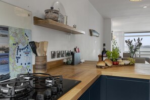 Eine moderne Küche mit Gasherd, Holz Arbeitsplatte und diversen Küchenutensilien.