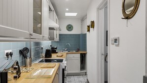 A modern kitchen with a sink, stove, and cabinets. - Pisces Cottage, a delightful Grade II listed two bedroom cottage in Brixham (Brixham)