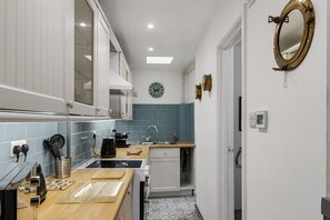 A modern kitchen with a sink, stove, and cabinets. - Pisces Cottage, a delightful Grade II listed two bedroom cottage in Brixham (Brixham)