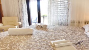 Una habitación de hotel con una cama grande, una silla y vistas al exterior.