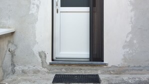 A door with a glass panel, a number '9' sign, and a small outdoor light fixture.