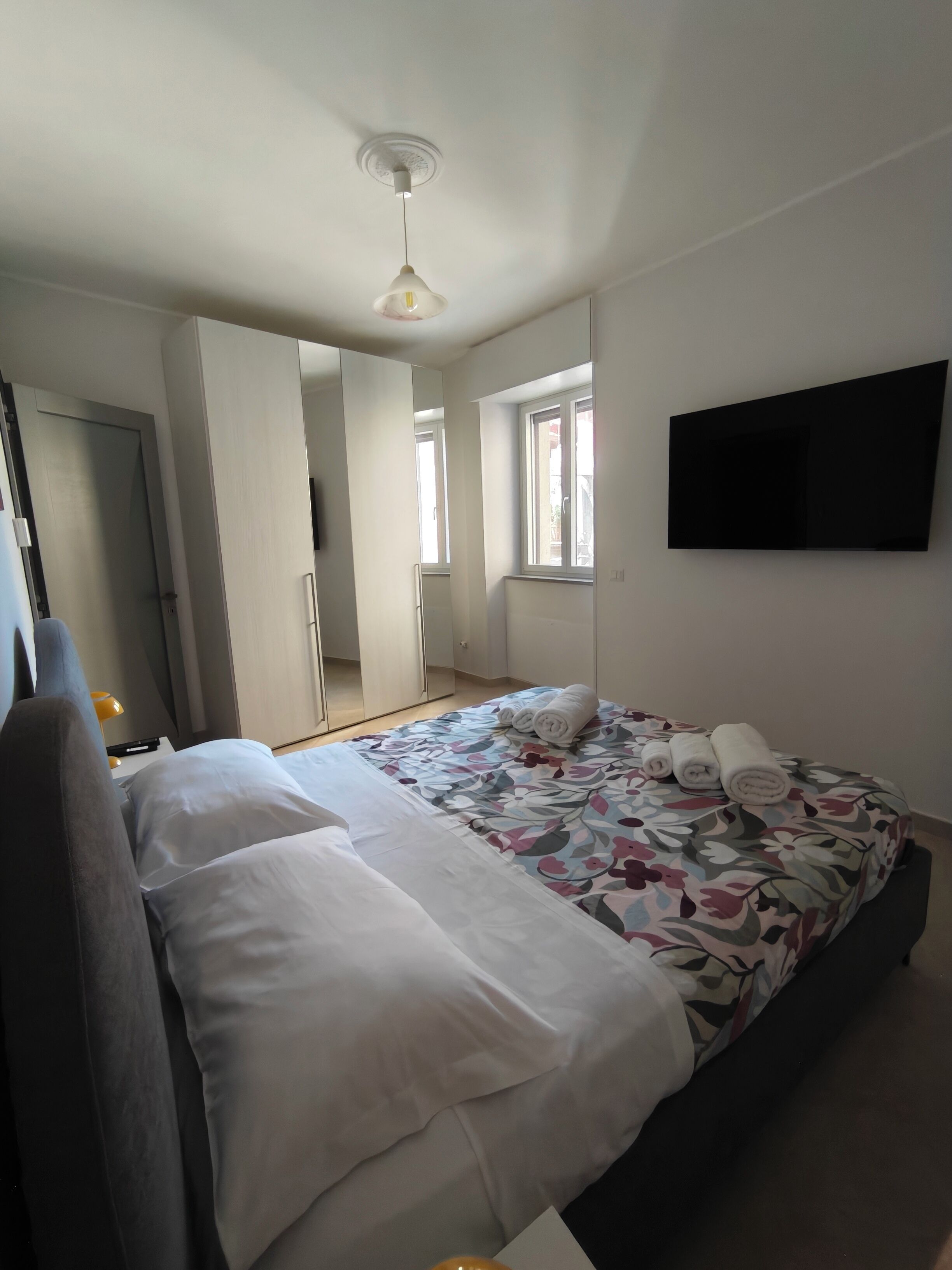 Habitació d'hotel amb un llit, televisió de pantalla plana, una finestra i una porta.