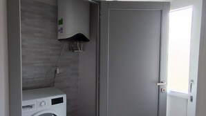 A laundry room with a washing machine and a water heater.