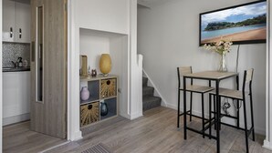 Una cucina moderna con mobili in legno, un'area pranzo con tavolo e sedie, e una scala che conduce a un altro piano.