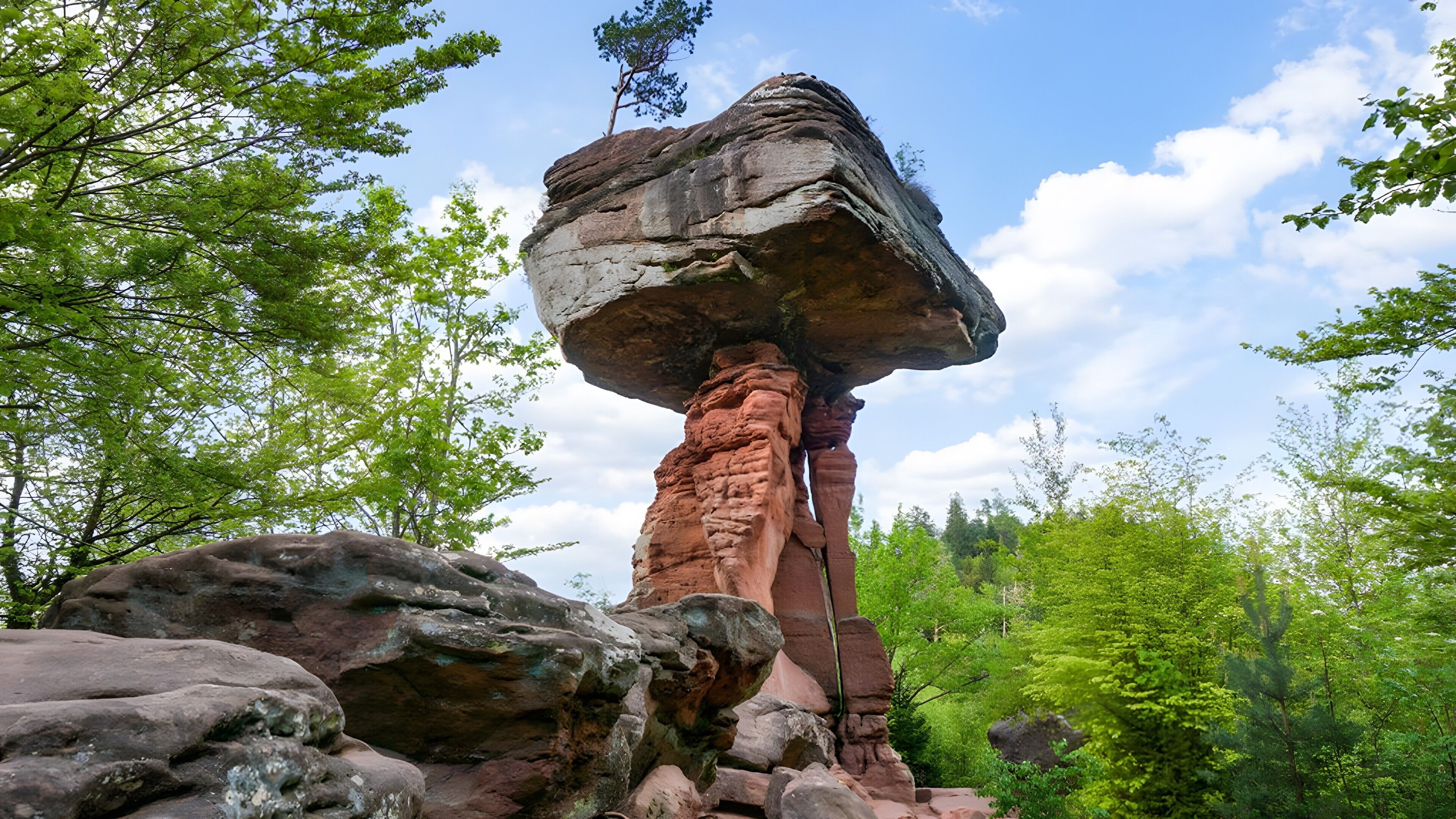 A natural rock formation with a balanced rock atop a pillar.