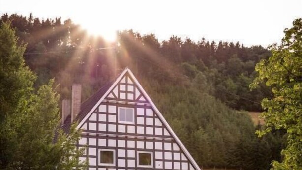 Ein traditionelles Fachwerkhäuschen mit einem Schild, das es als Hotel kennzeichnet.