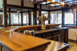 Una zona de bar con grifo de cerveza, mostrador y vigas de madera.