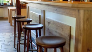 Eine Bar mit Holzhockern, einer Uhr und einem Schrank für Gläser.
