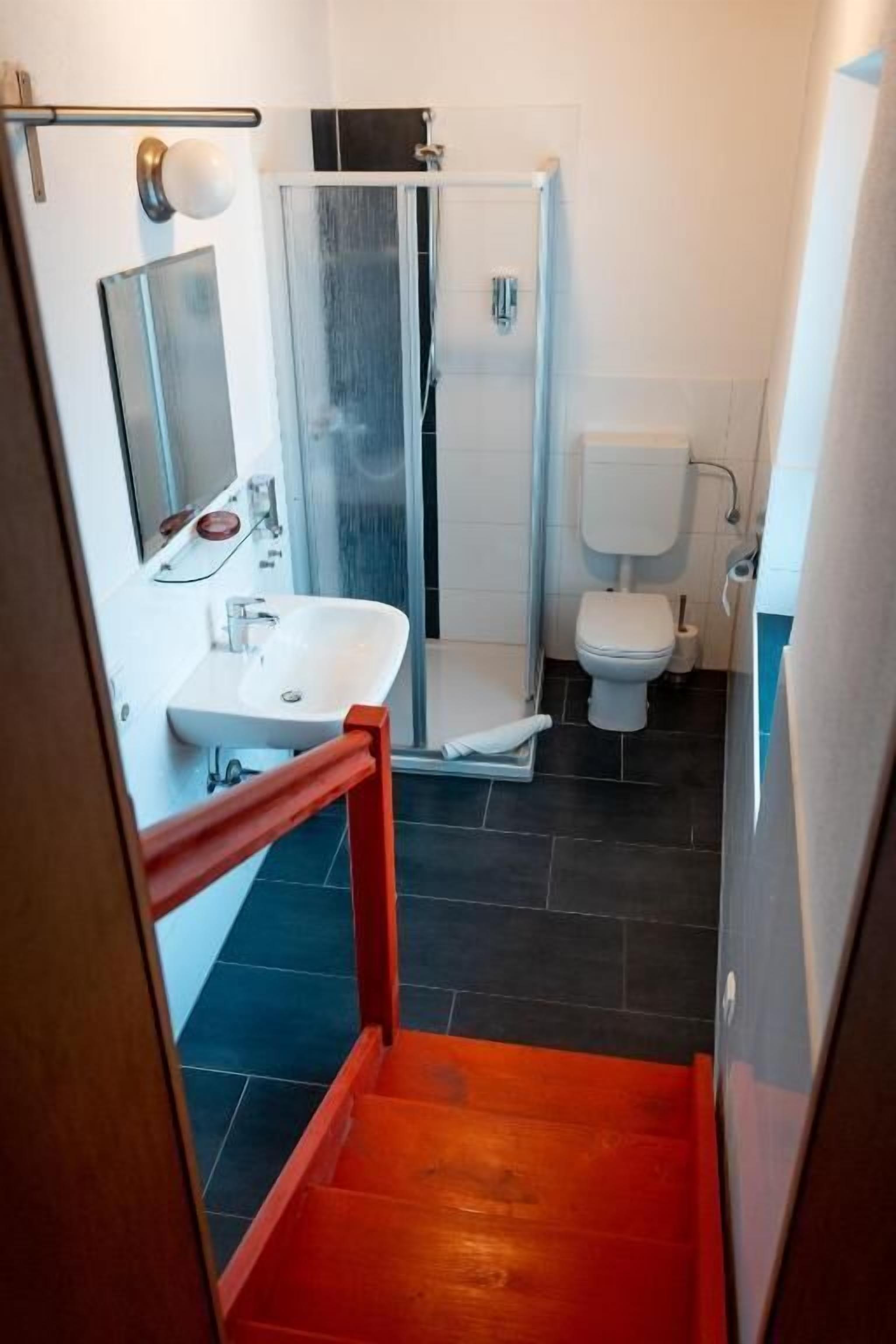 Baño con ducha, inodoro y lavabo.
